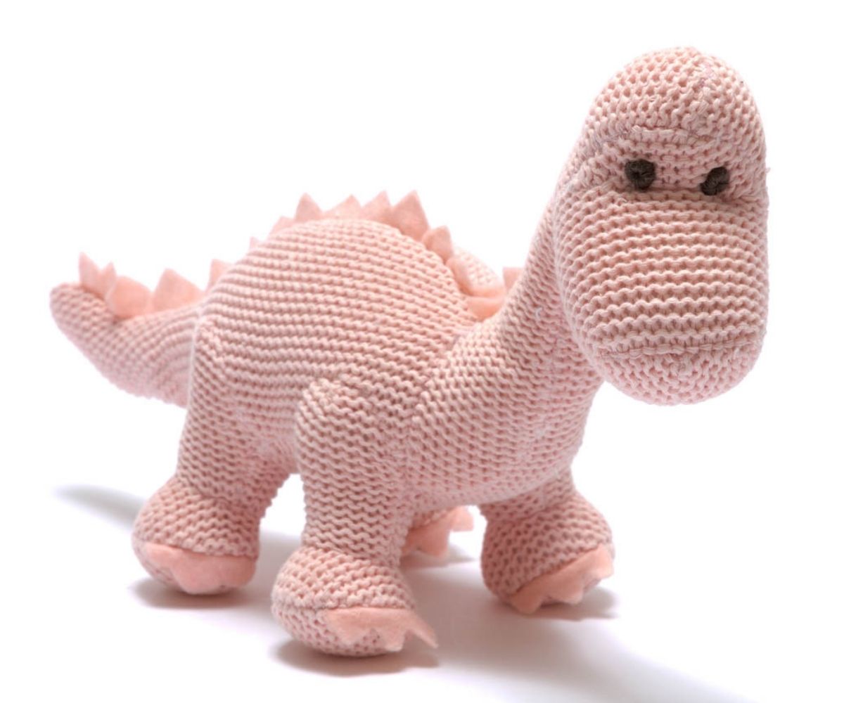 Pastel pink knitted diplodocus dinosaur baby toy with long neck.